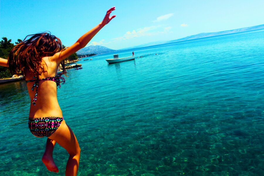A lady hopping into the ocean