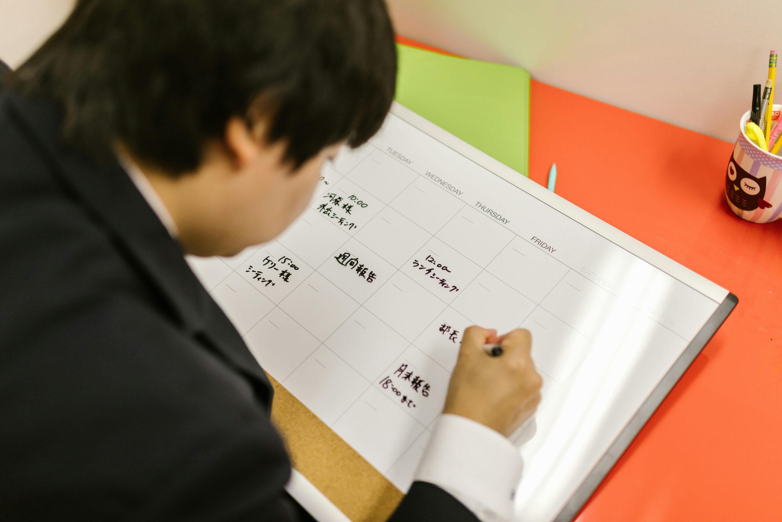 A man writing on a calendar